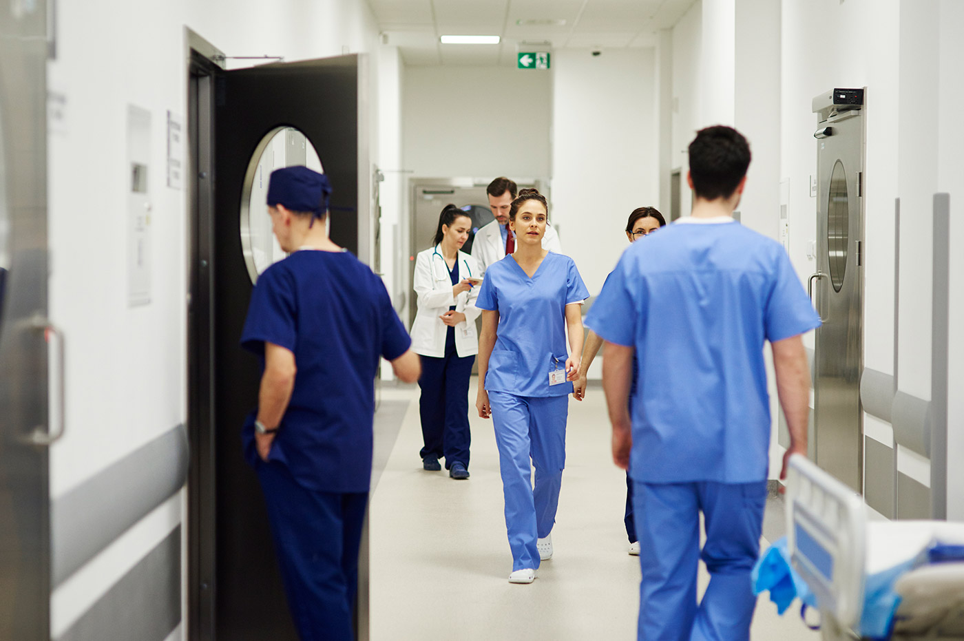 Multiple healthcare workers walking in hallways.
