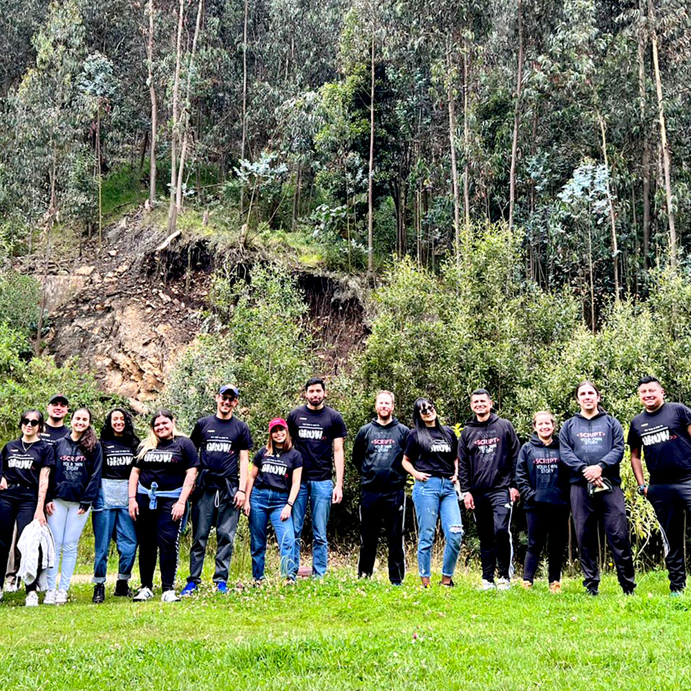 A group of people standing in front of trees. 