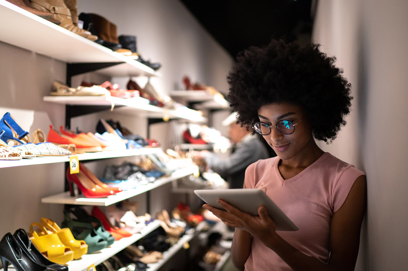 A woman using a tablet at a shoe store.