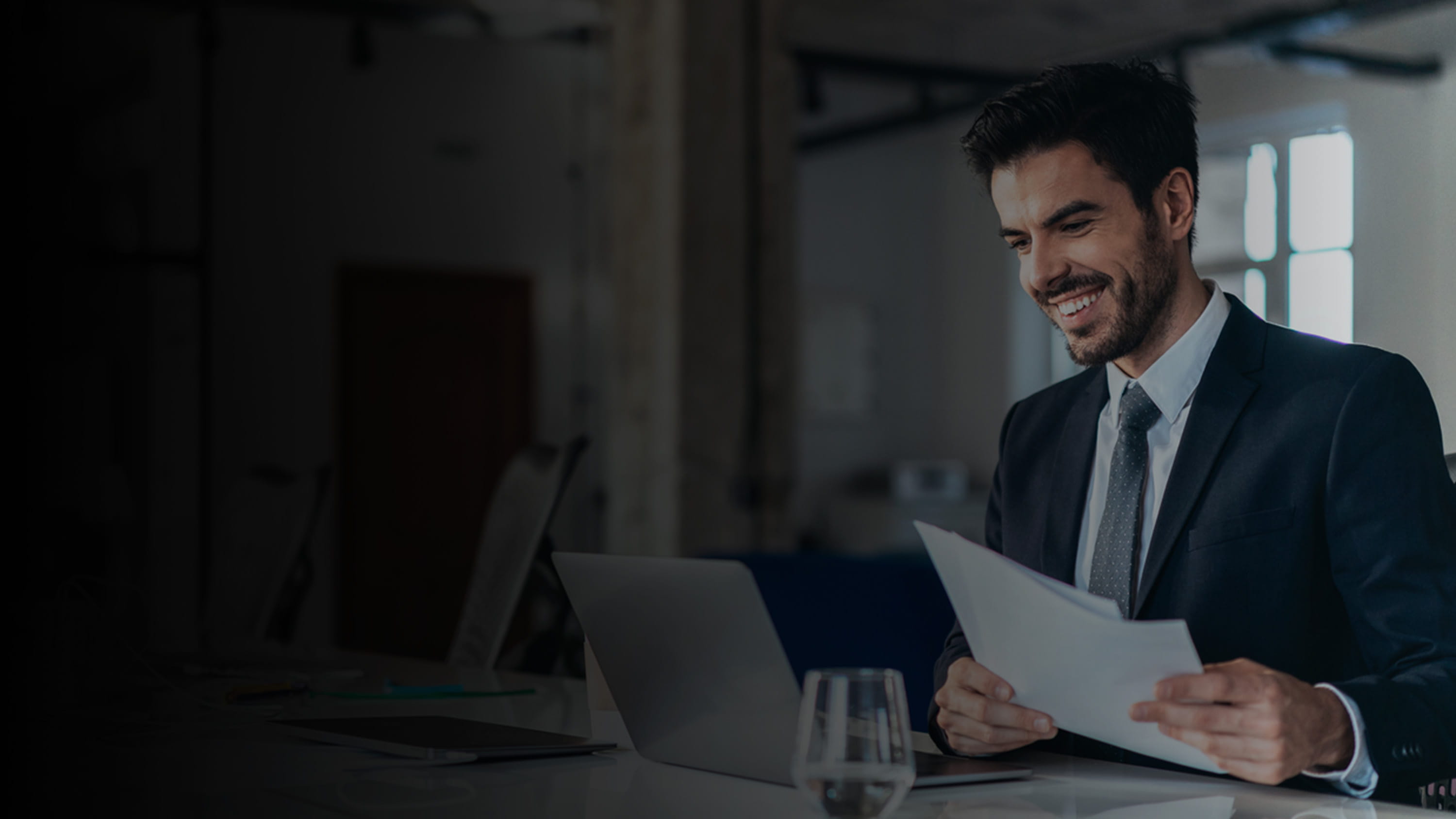 Man looking at a tablet and holding a piece of paper