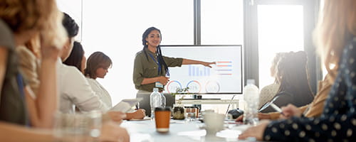 A woman presenting data to a team.