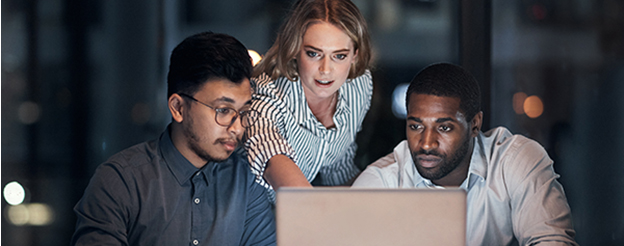 Three people working on a laptop