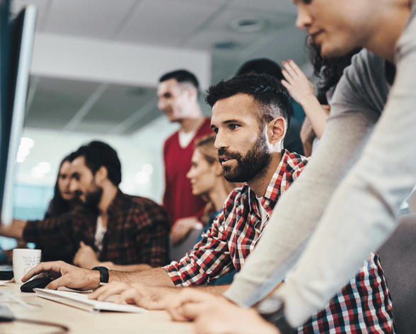 A group of coworkers all looking a computer screen