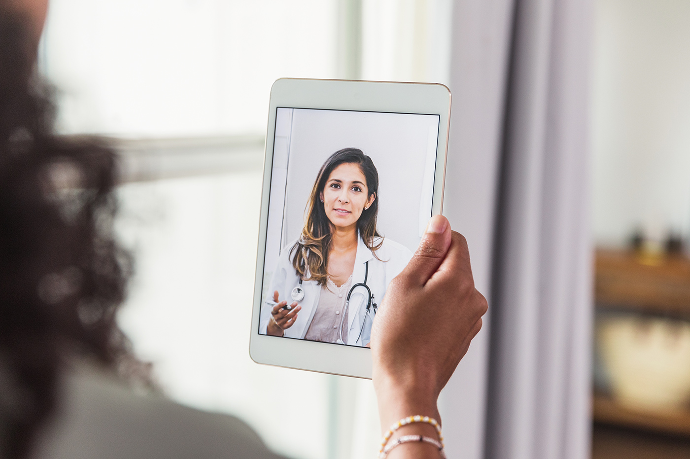 Woman holding iPad for virtual doctor visit