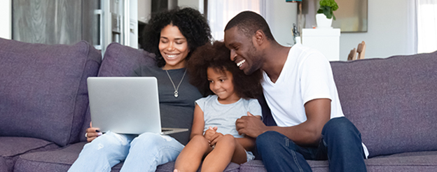 A family smiling and looking at a tablet