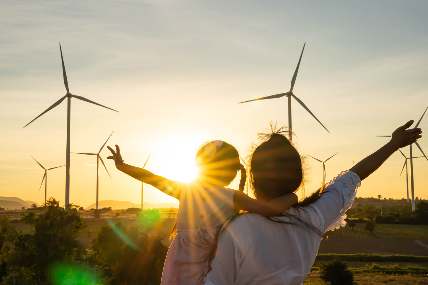 A father and daughter in a field of windmills.