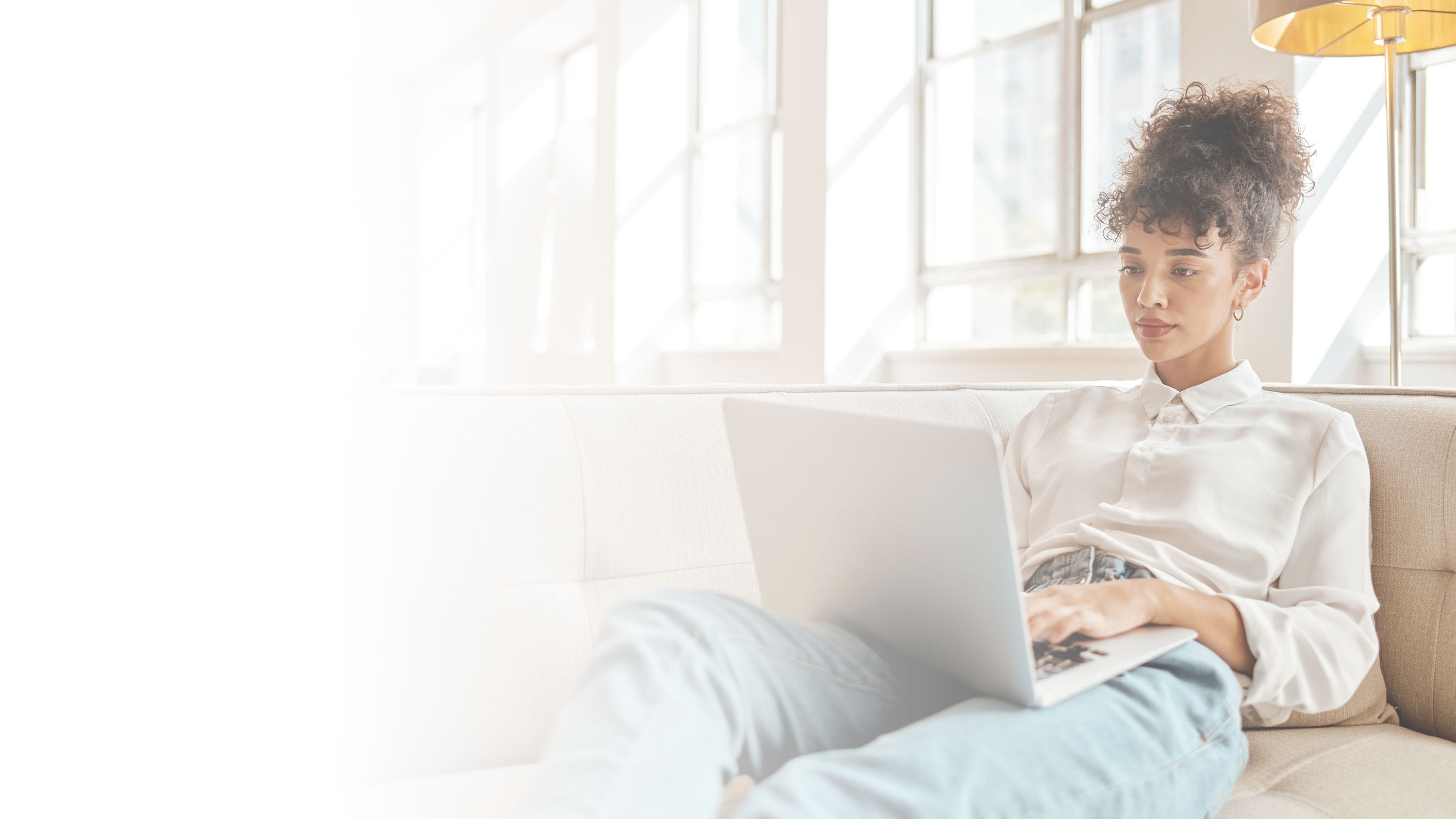 A woman working on a laptop, gradient image.