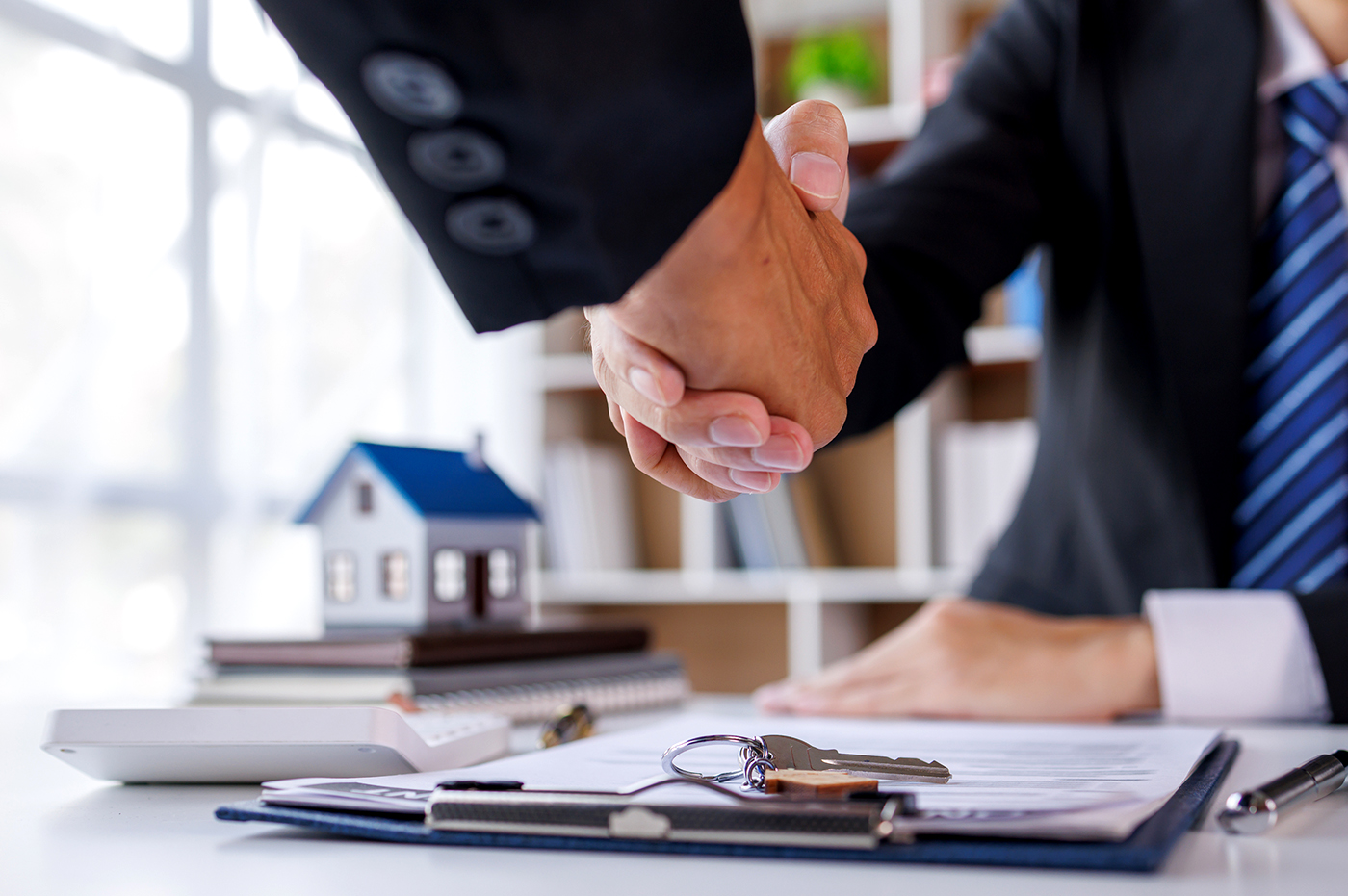Two people shaking hands in an insurance office.