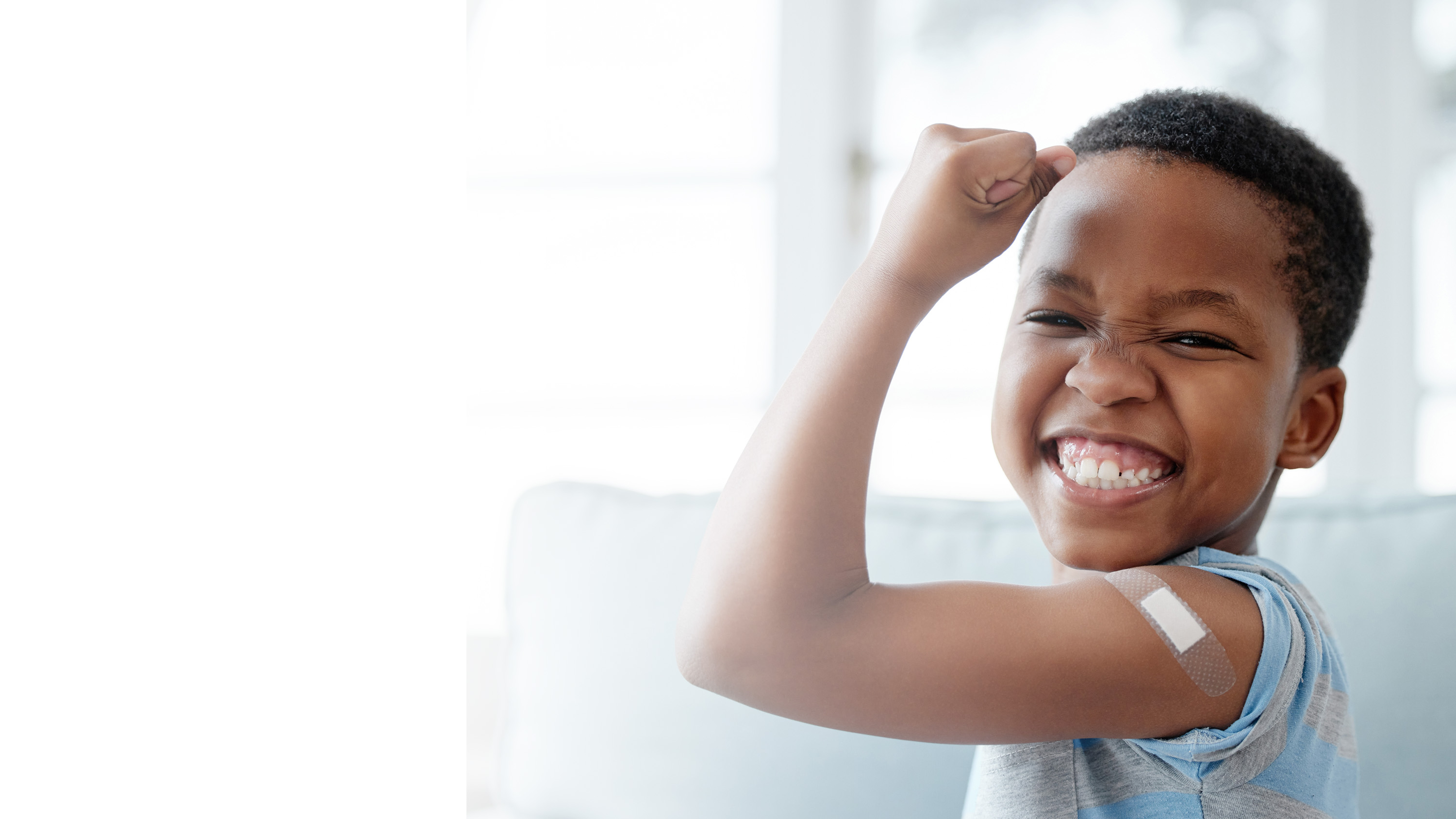 A little boy making a muscle arm to show a bandage, gradient.