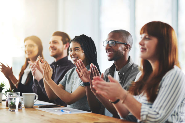 A group of businesspeople applauding in an office