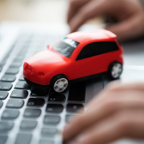Toy Car sitting on top of a laptop