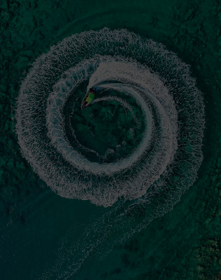 A jetski leaving a spiral of ripples in the water.