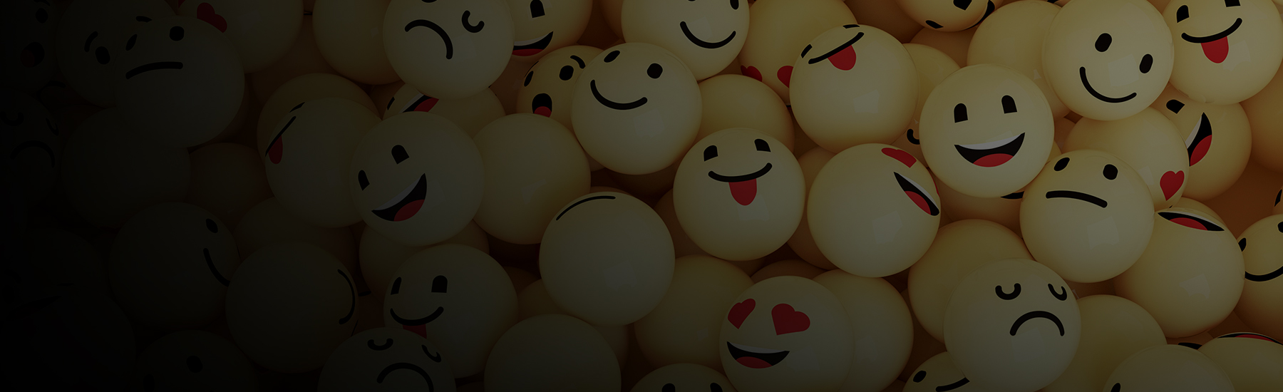 Bouncy balls decorated with different smiley faces, desktop hero.