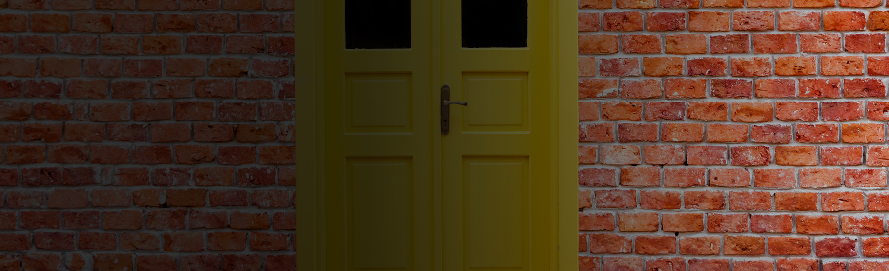 Yellow door on a brick wall