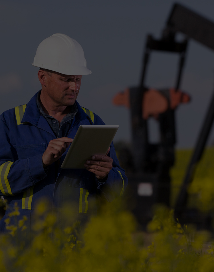 An oil worker using a tablet at a drilling site, mobile hero.