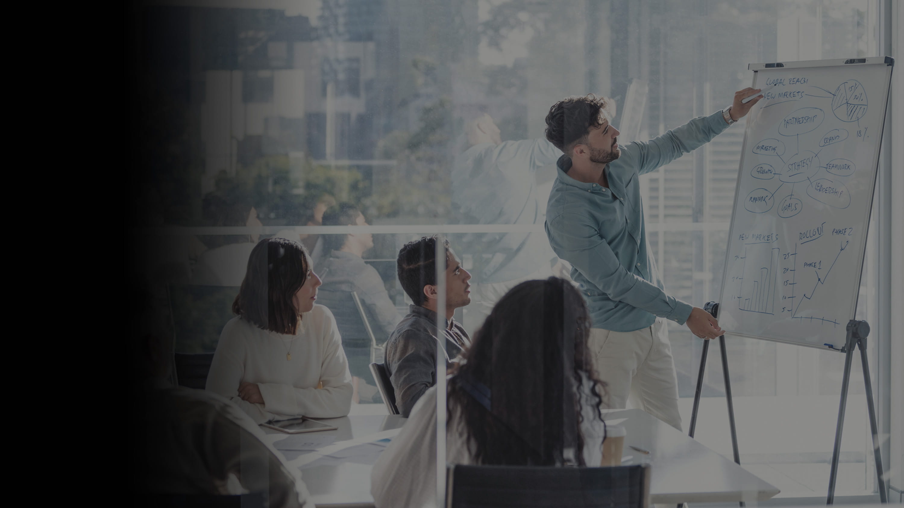 Gradient image of a work team strategizing on a whiteboard in a conference room.