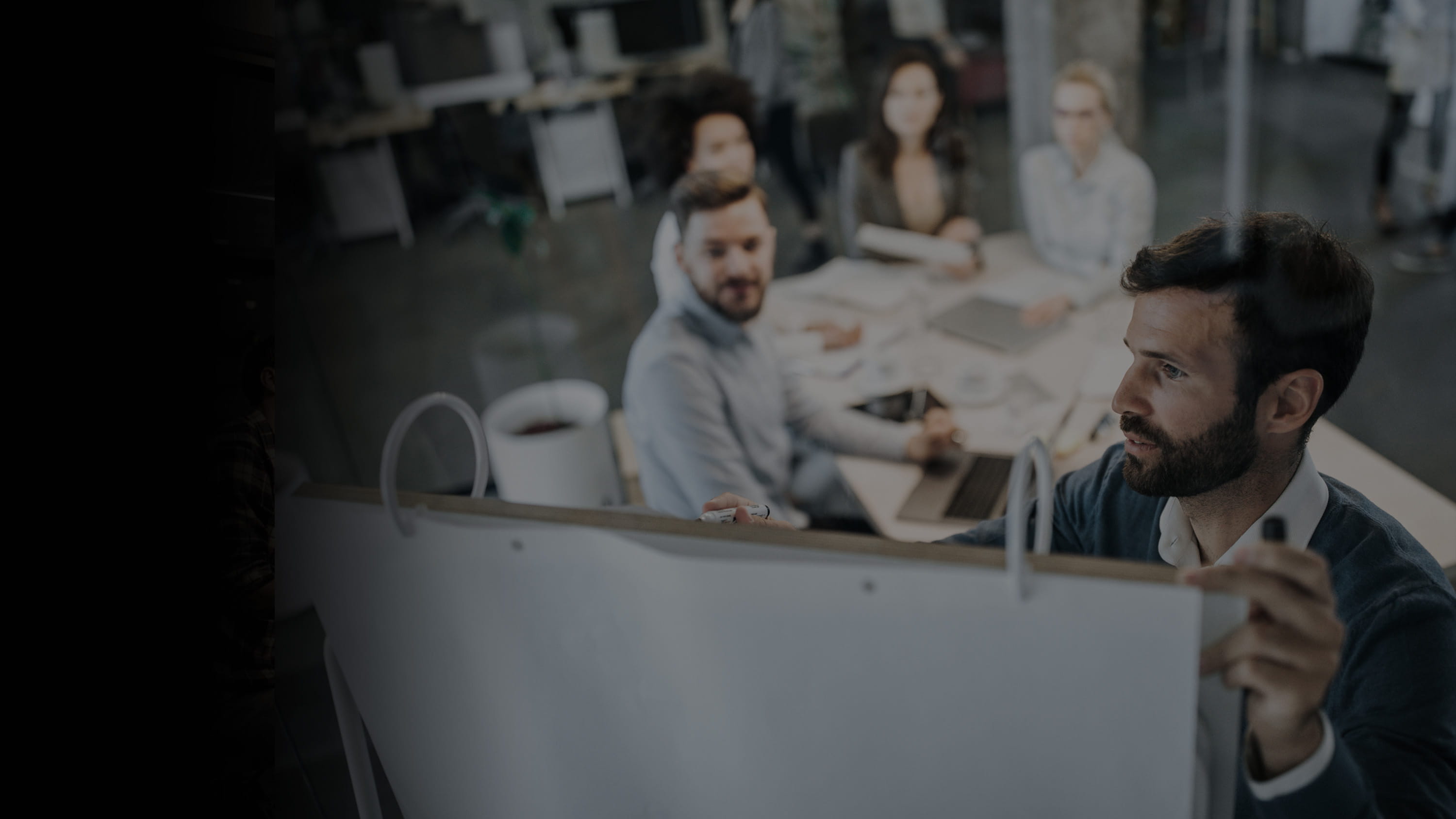 Group of colleagues exchanging ideas during a brainstorming meeting in a conference room.