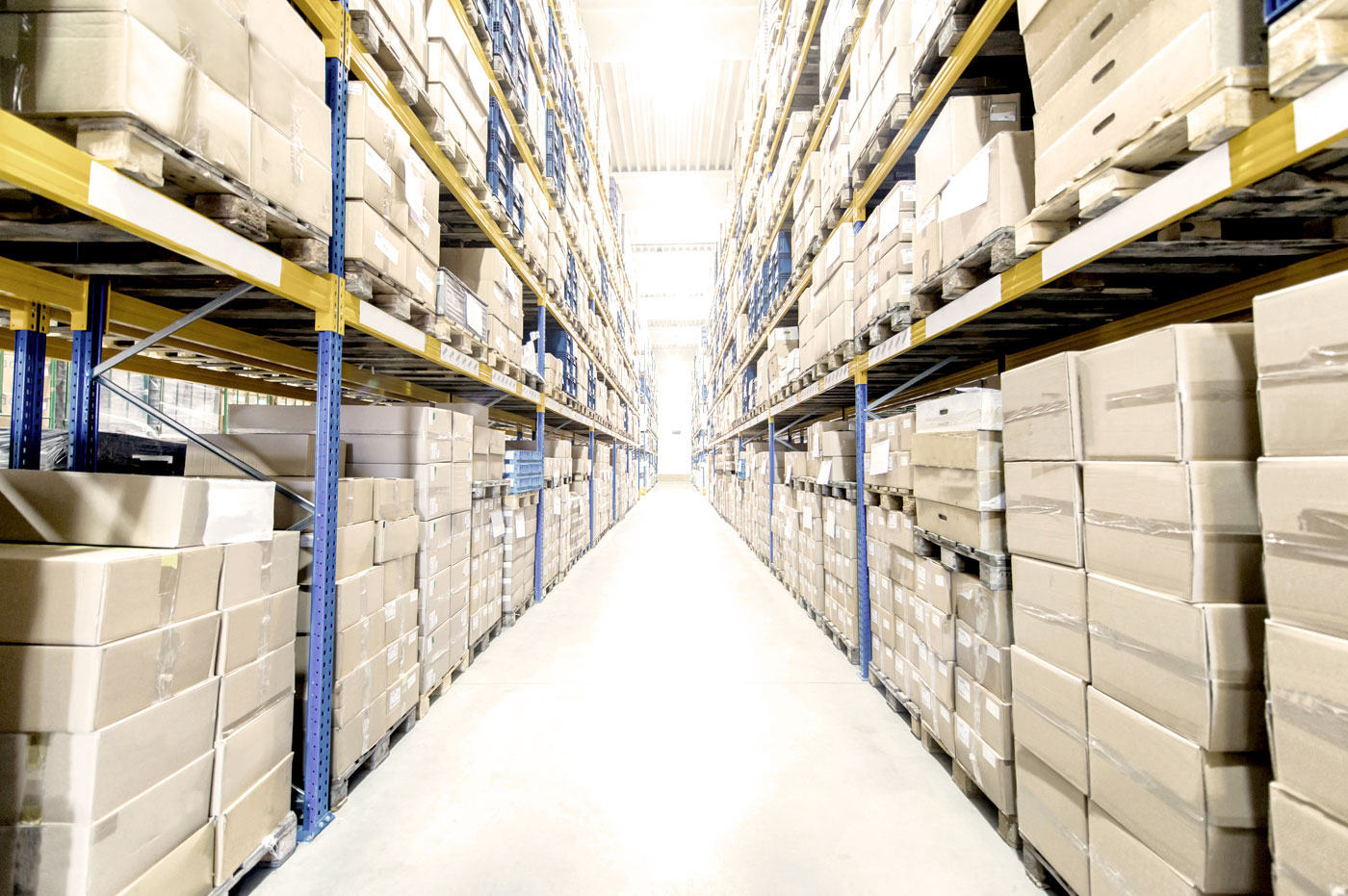 An aisle full of boxes in a warehouse.