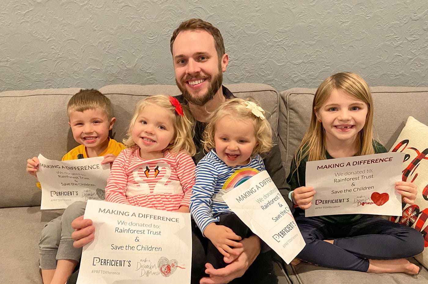 A colleague with his four young children holding MADD signs for Rainforest Trust and Save the Children.