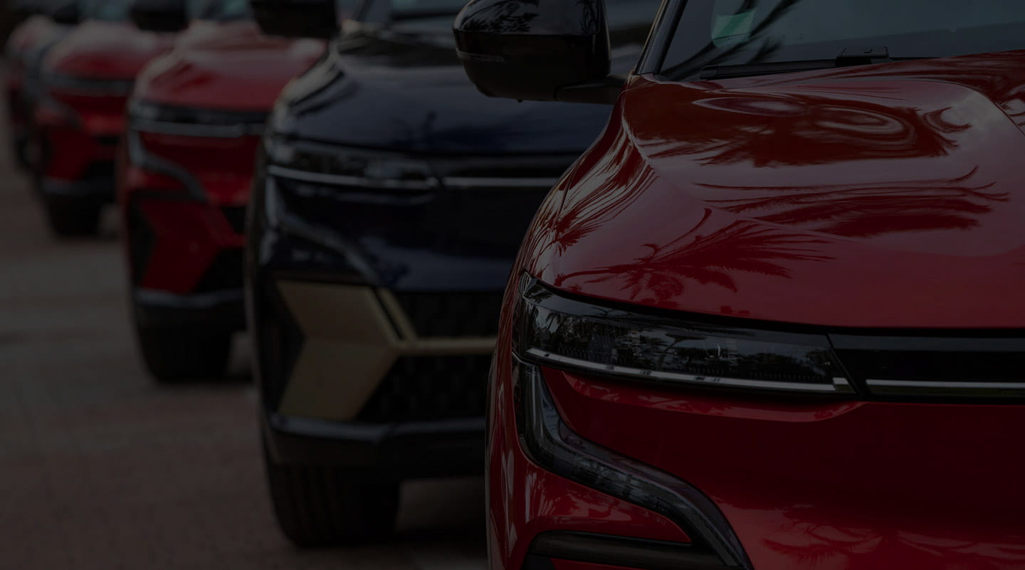 A row of red cars with one black car.