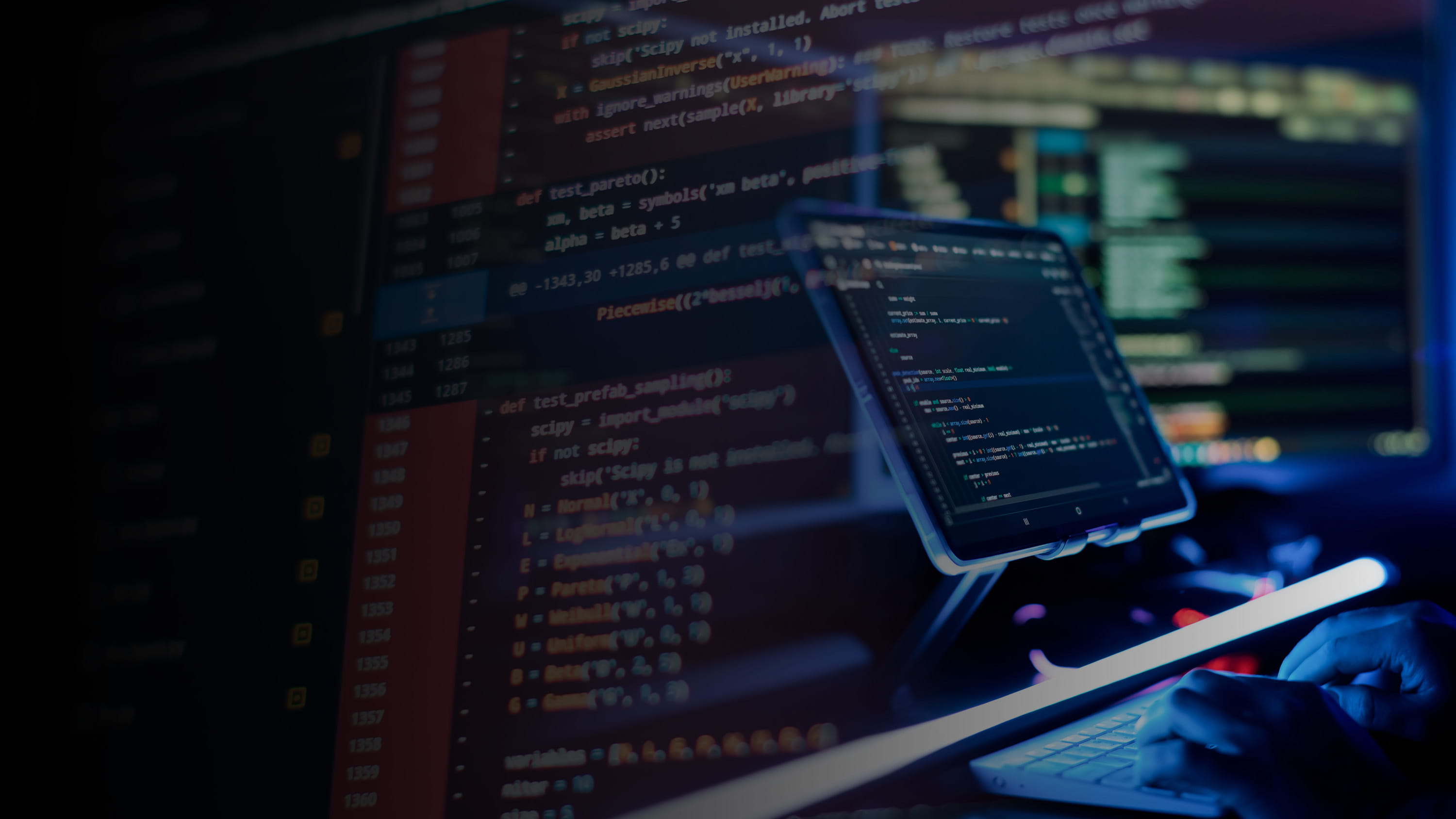 Computer and large screen with lines of code.