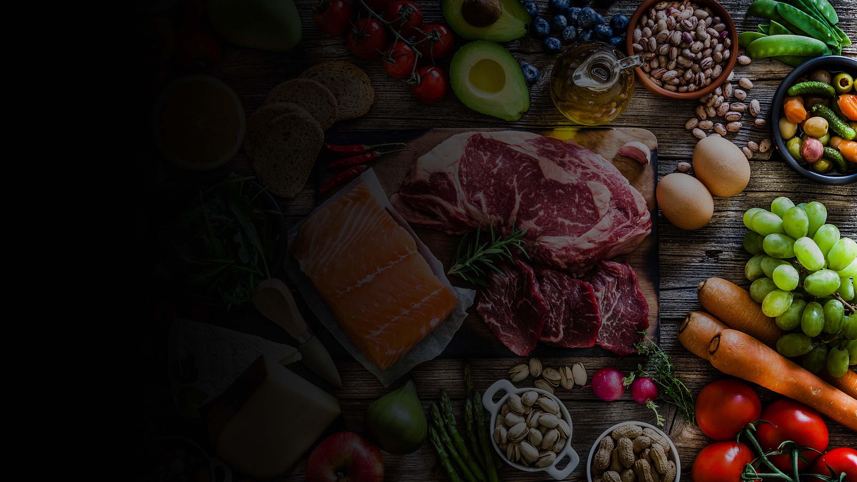 Colorful display of groceries, fruits, vegetables, meats, and cheeses.
