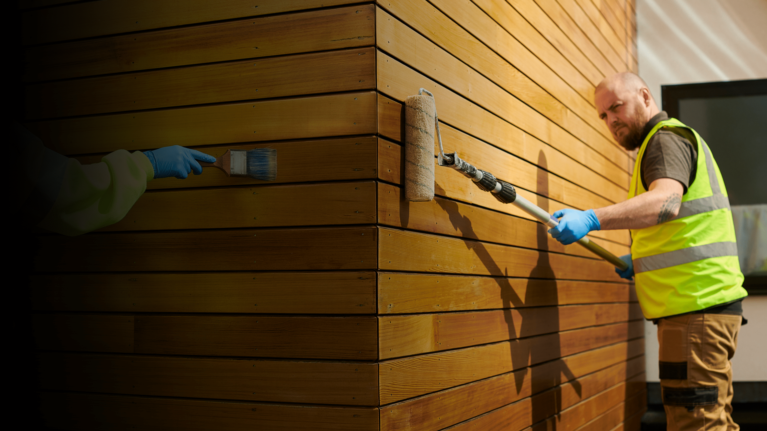 Two people painting wood.