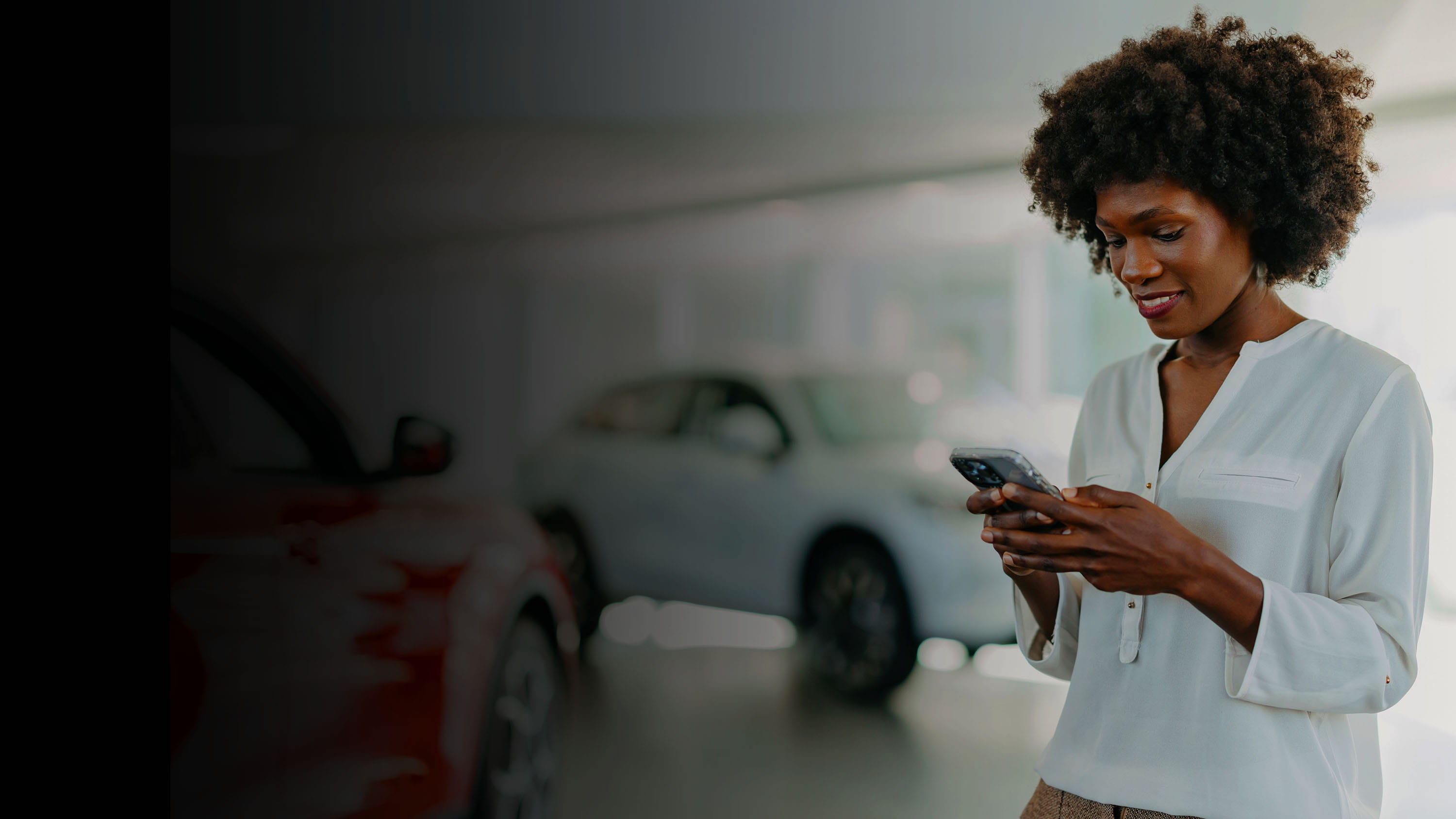 Person looking at phone in car showroom