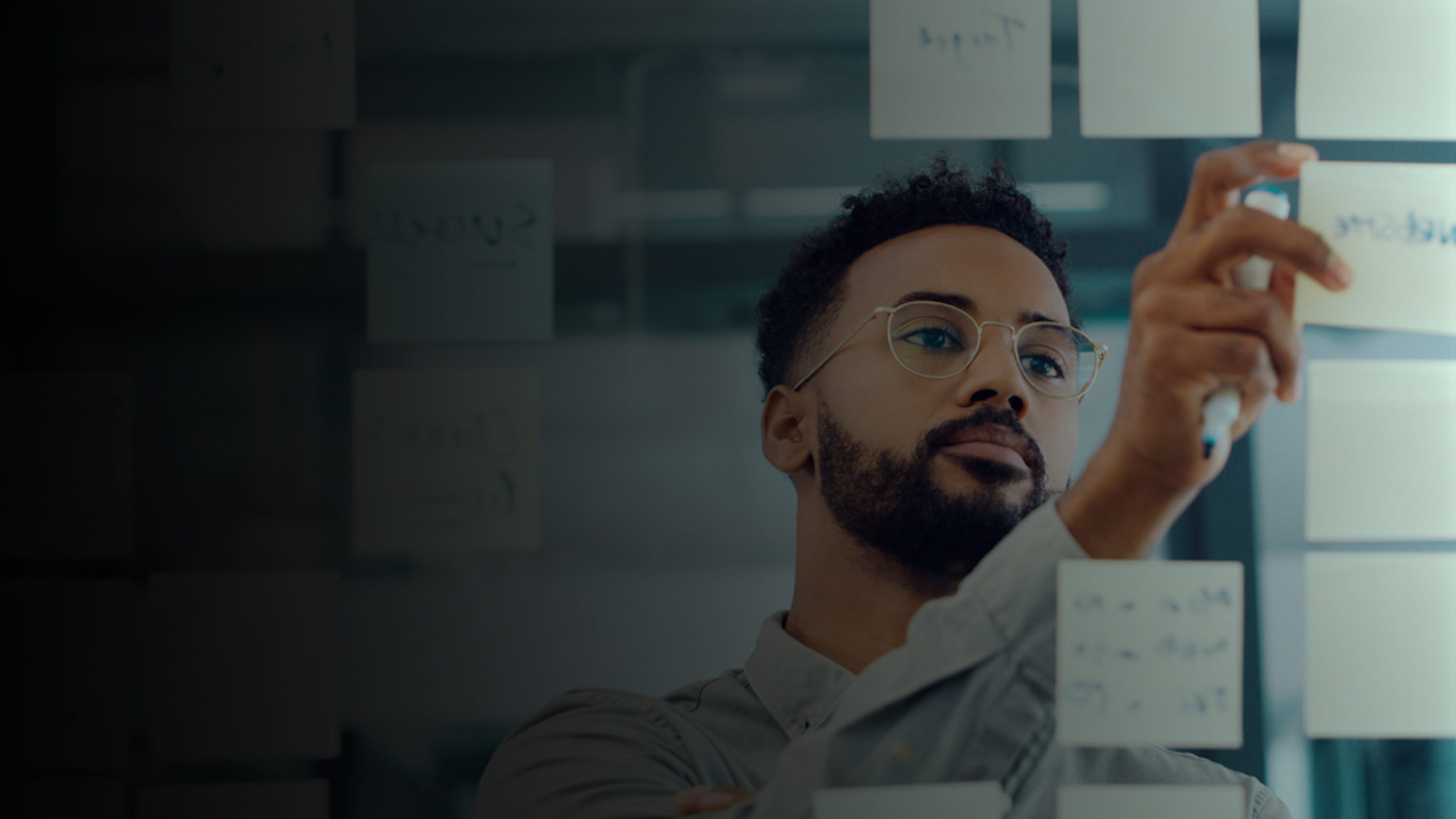 Man looking at a board full of sticky notes