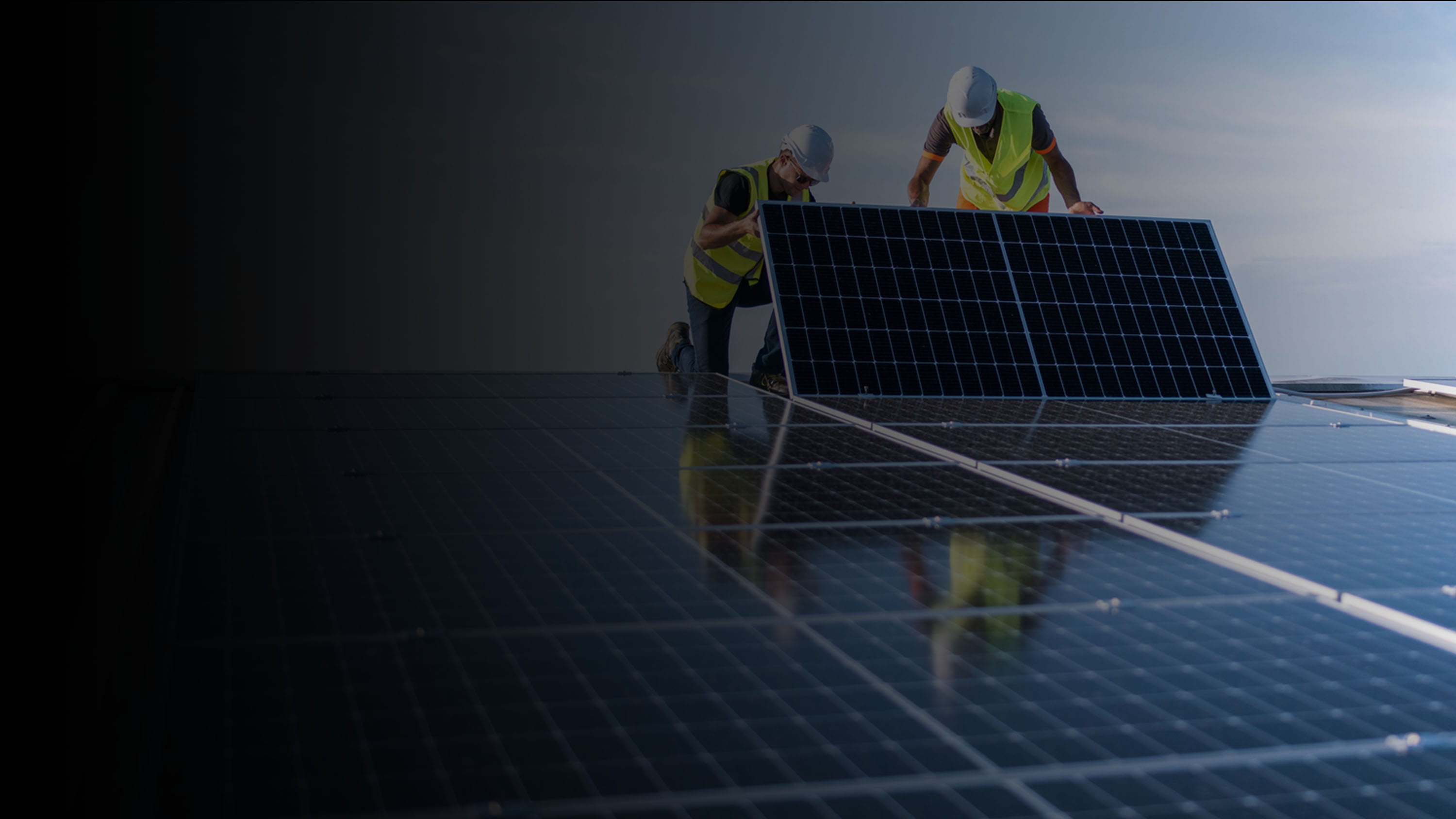 Two utility workers installing a solar panel on a roof.