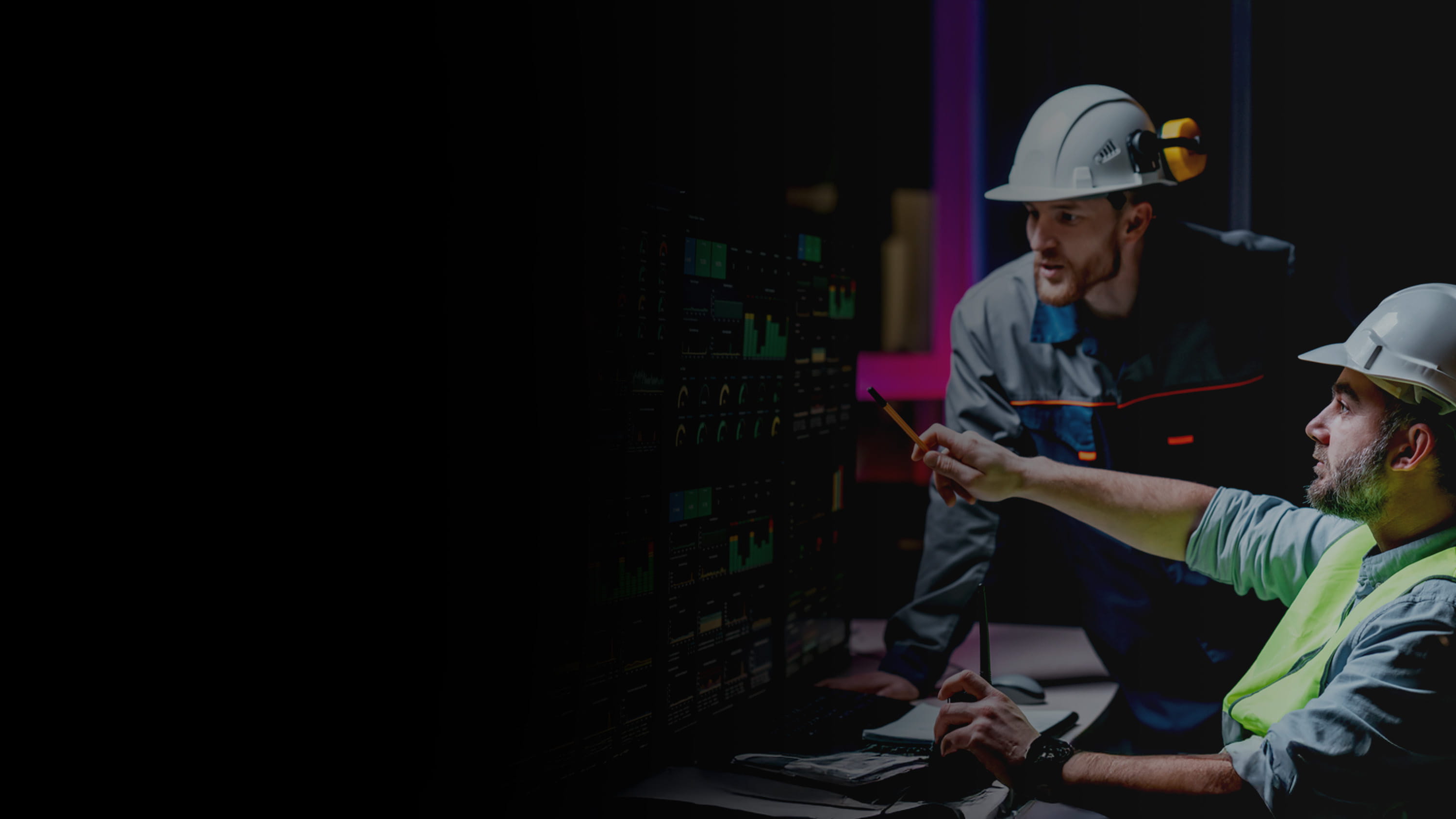 Construction works looking at charts on multiple computer screens