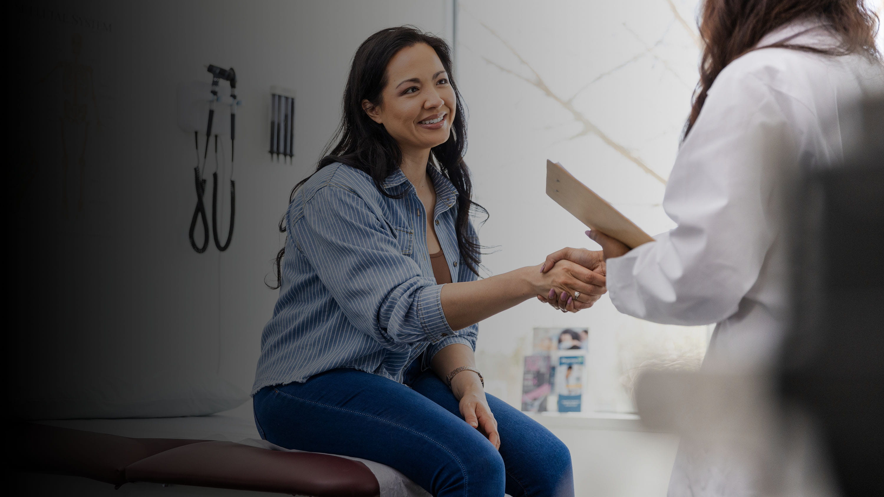 A woman shaking hands with a doctor.