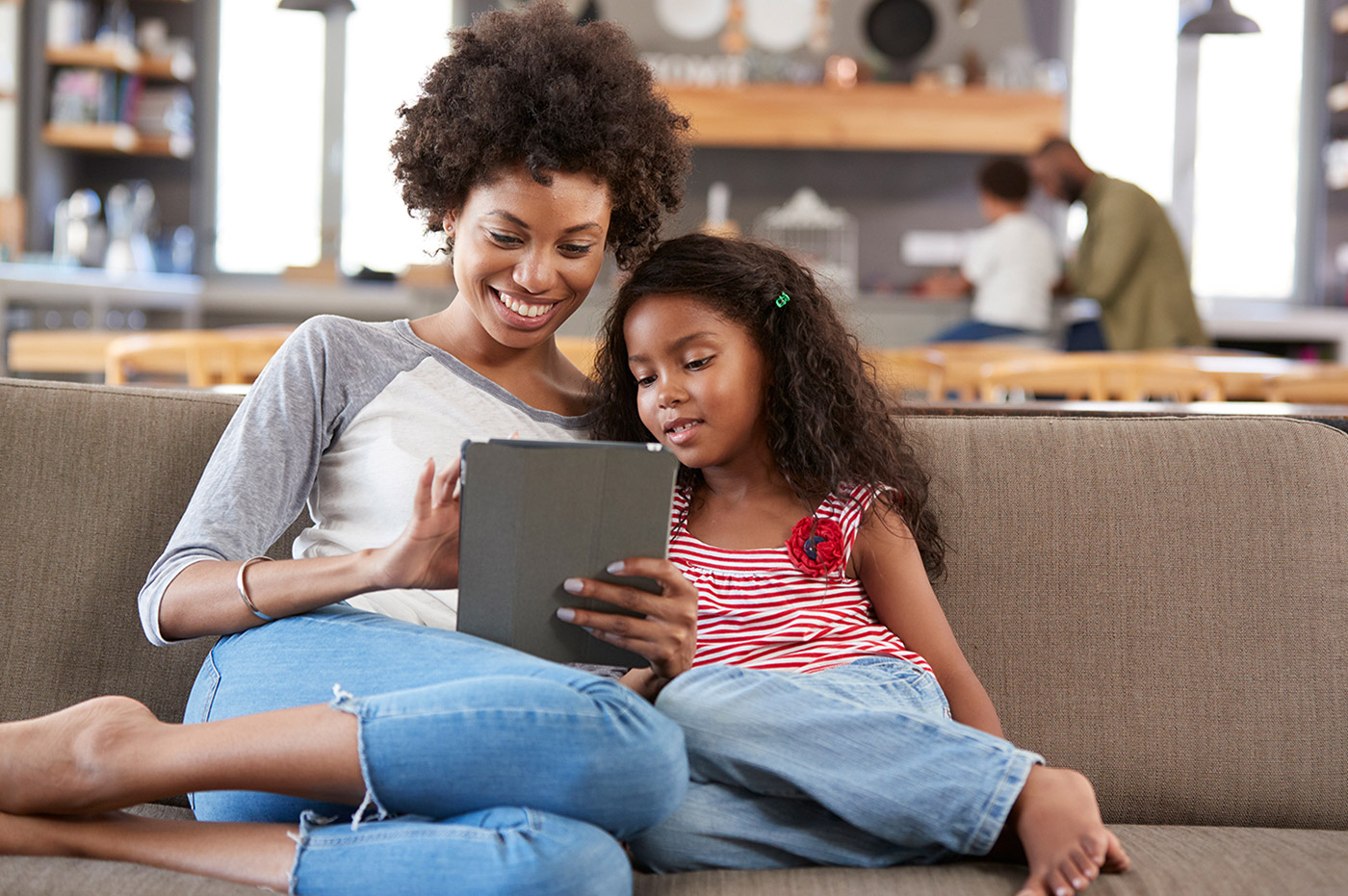 African-American mother and daughter looking at an iPad together.