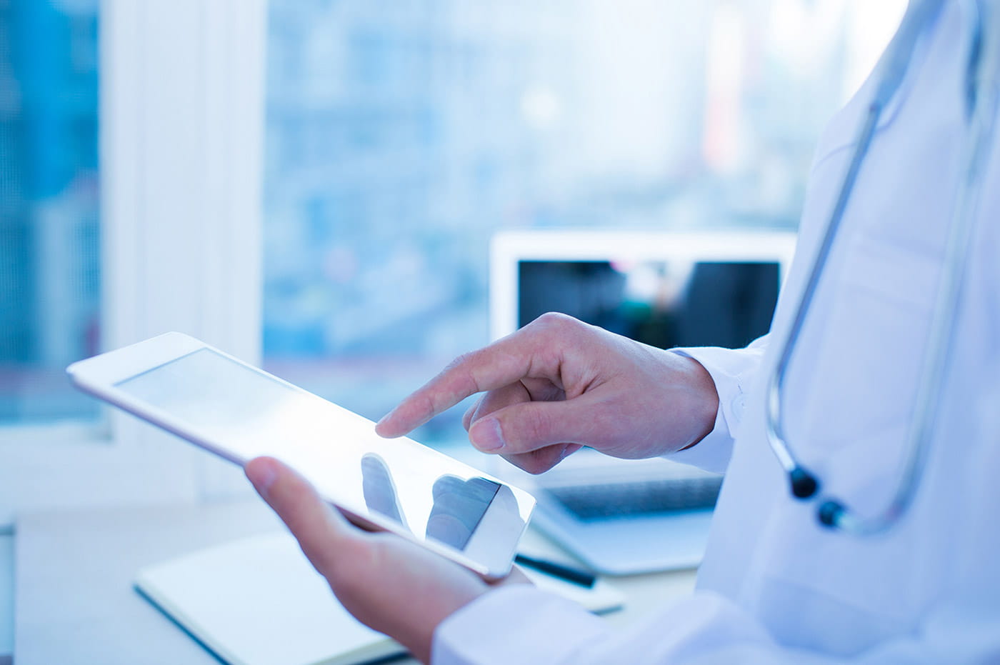 A doctor's hands while working on an iPad.