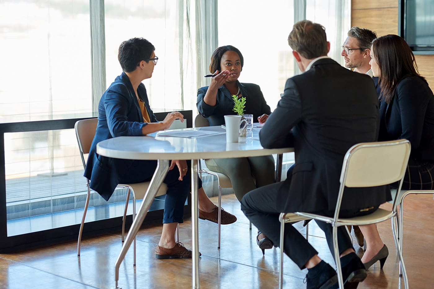 Business professionals sitting at a table having a discussion.