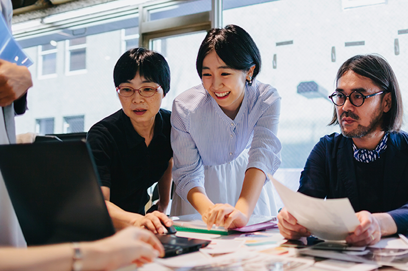 A group of colleagues working together on a computer.