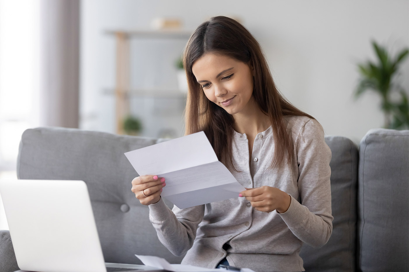 A woman reading a letter while working from home.