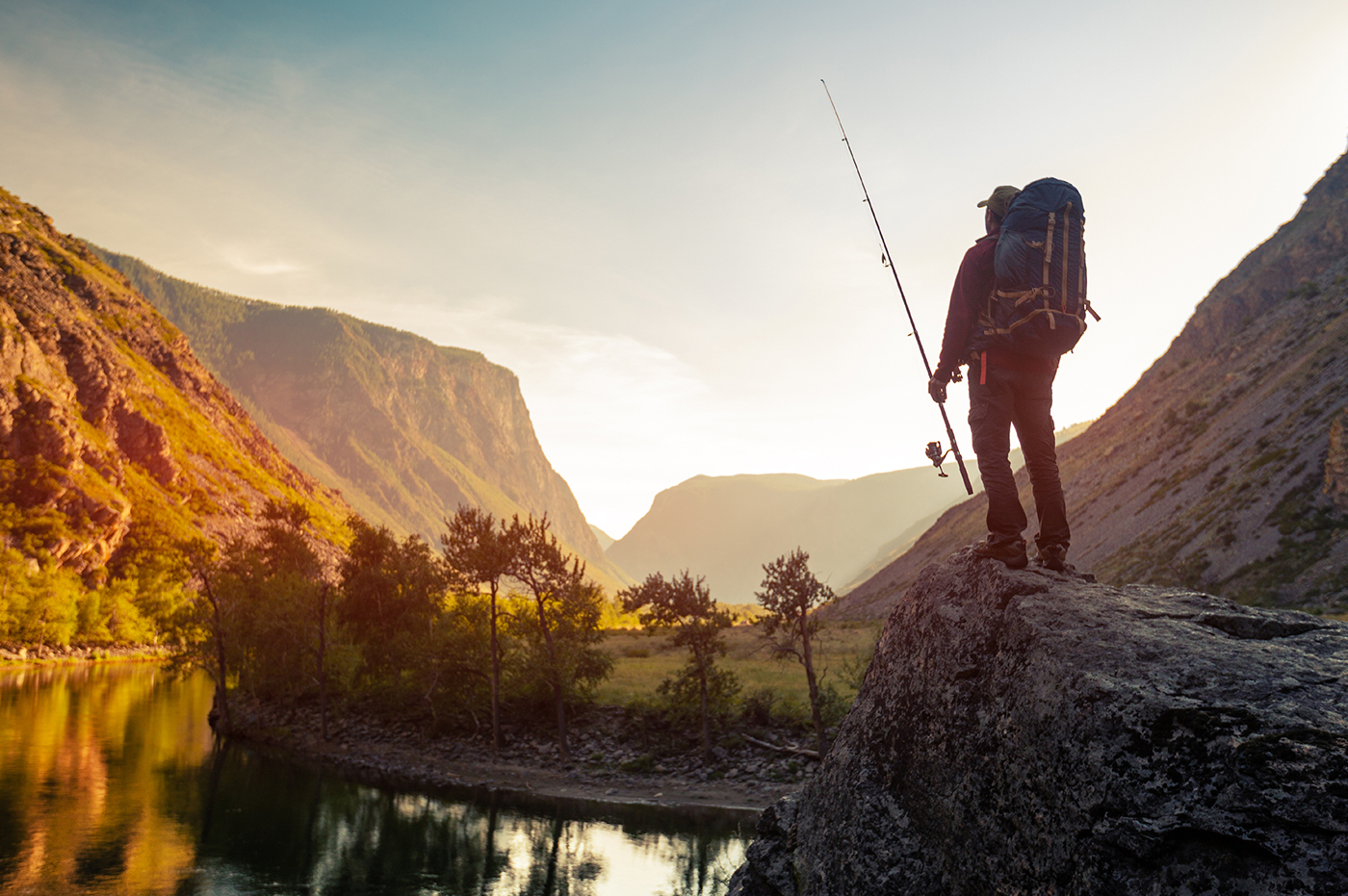 A man fishing in a mountainous area.