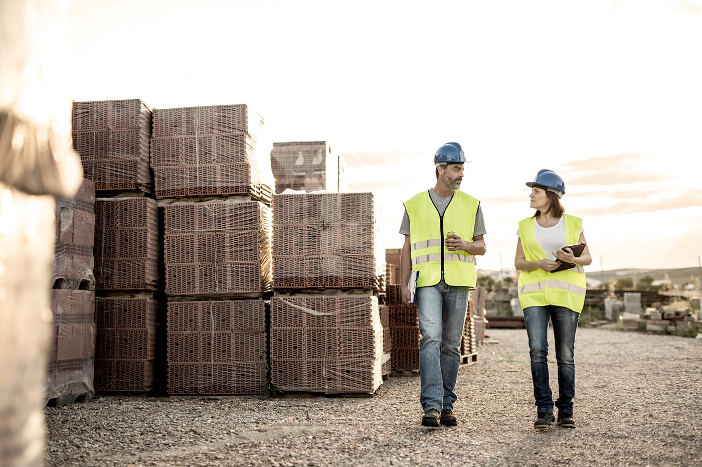 Man and Woman construction workers talking at a worksite. 