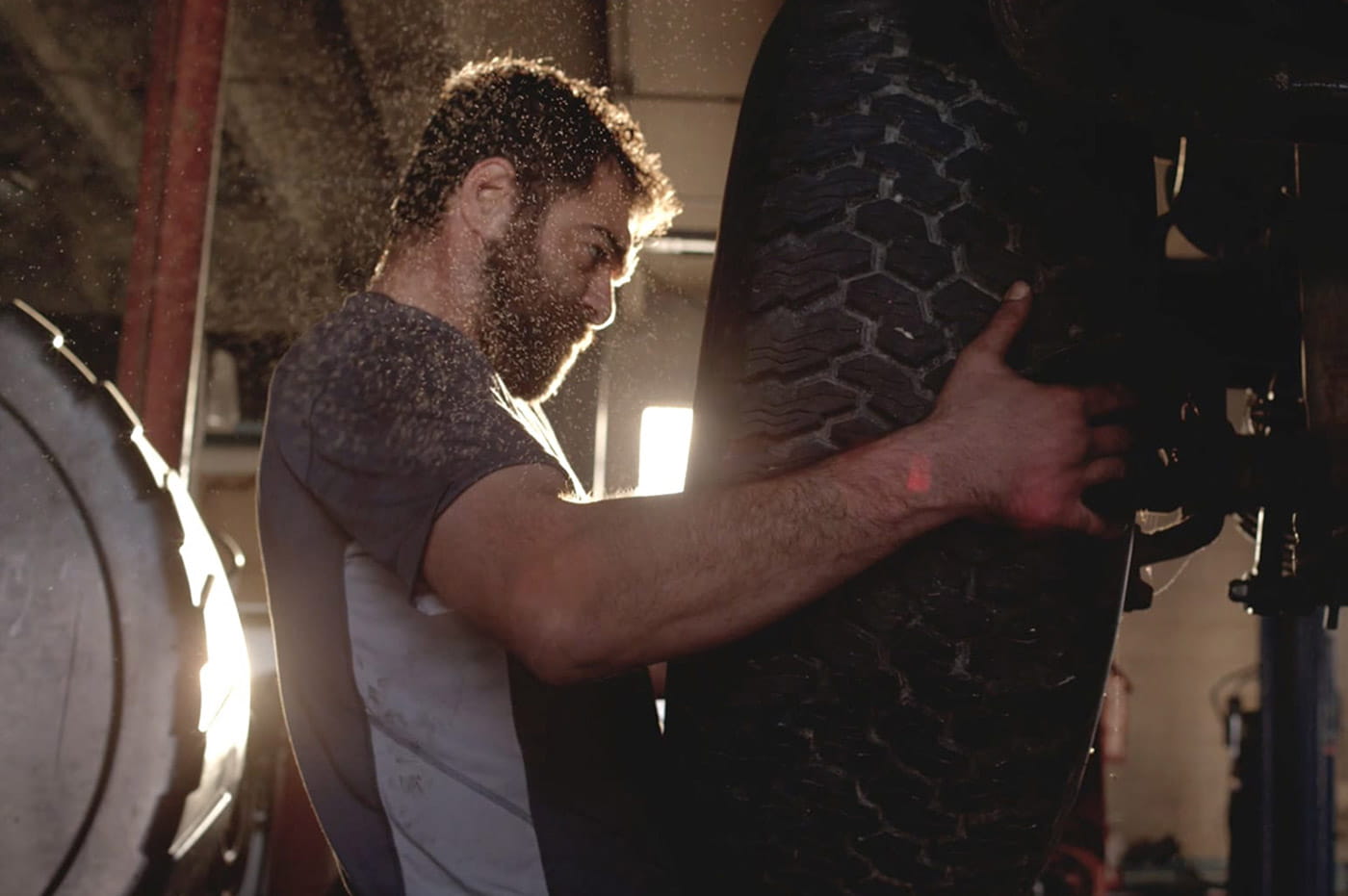 Man putting a new tire on a car.