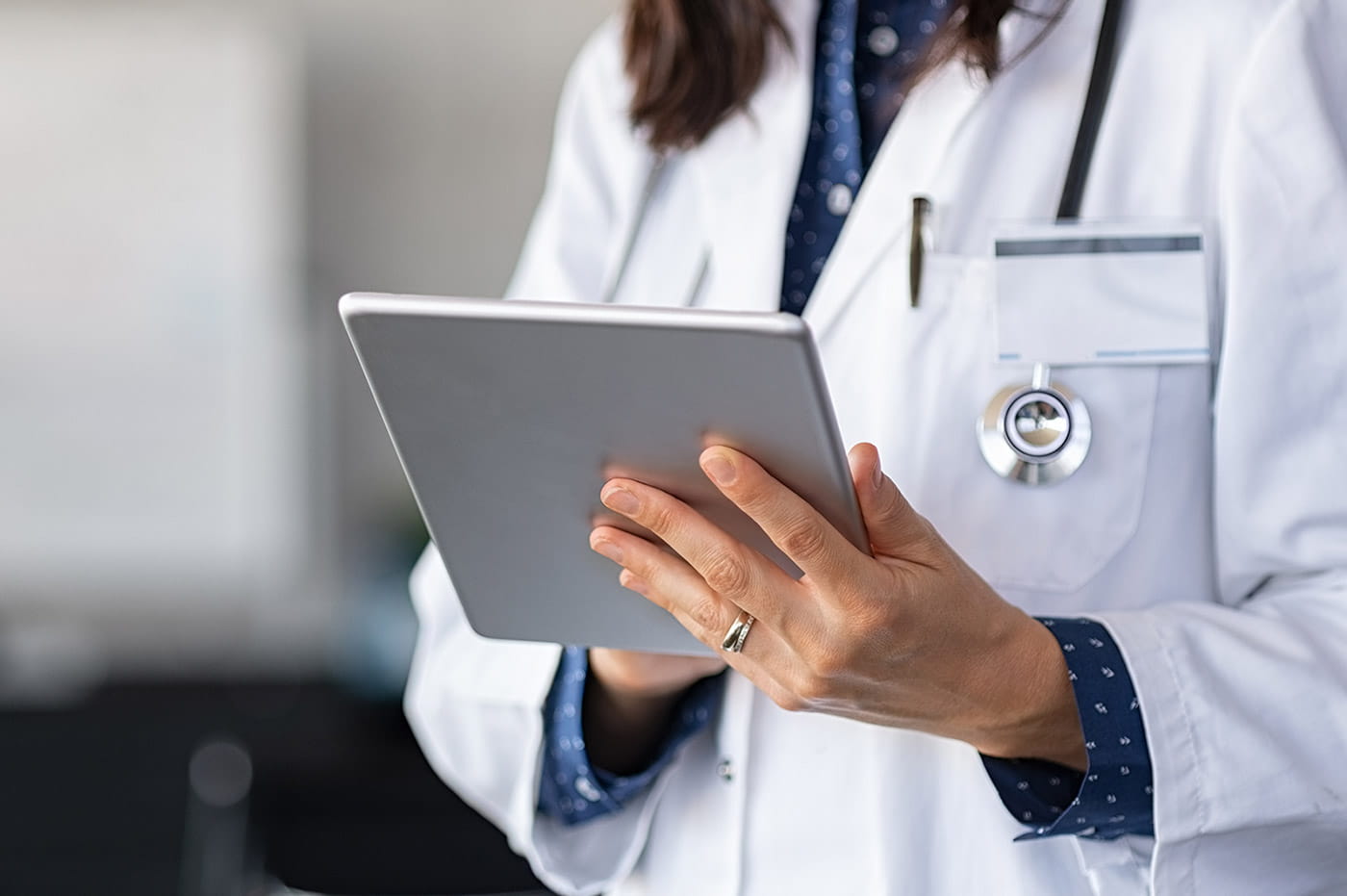 Woman in a labcoat working on an iPad.