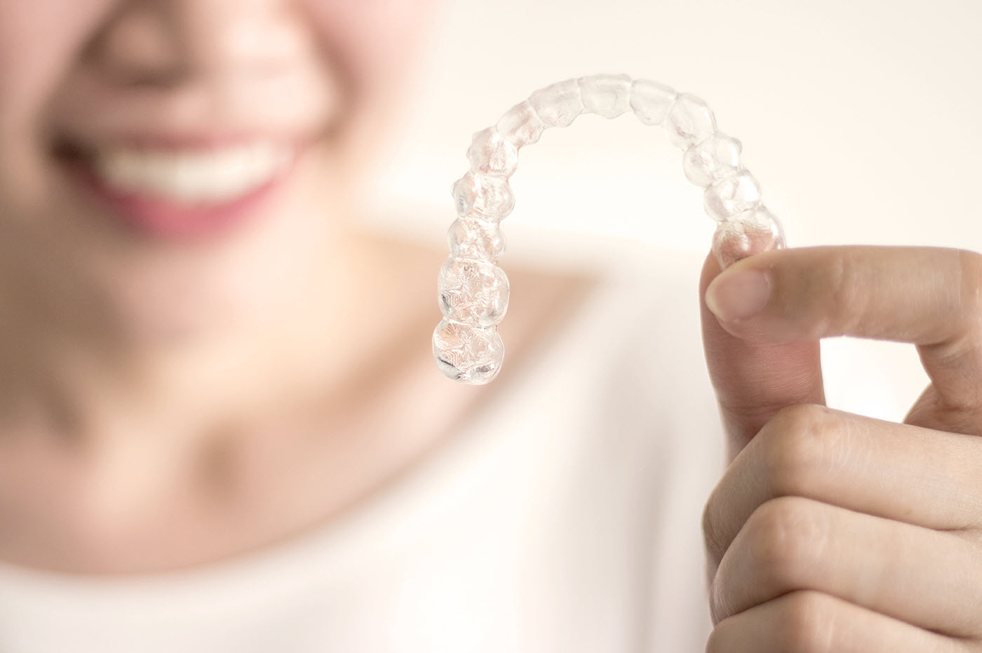 Person holding up a clear orthodontic retainer.
