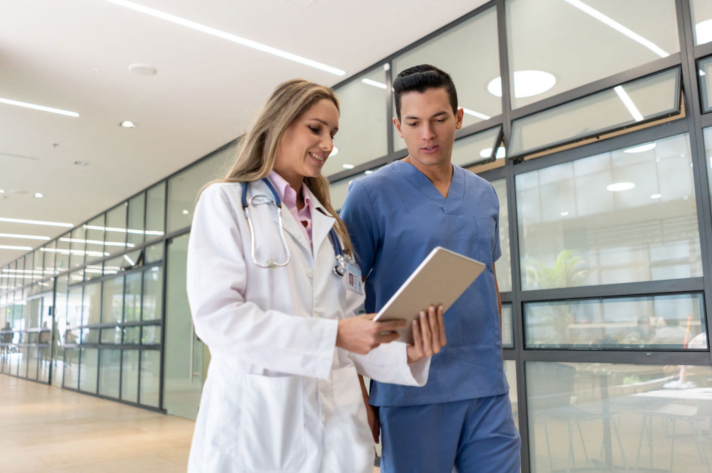 Female doctor and male nurse looking at an iPad and talking.