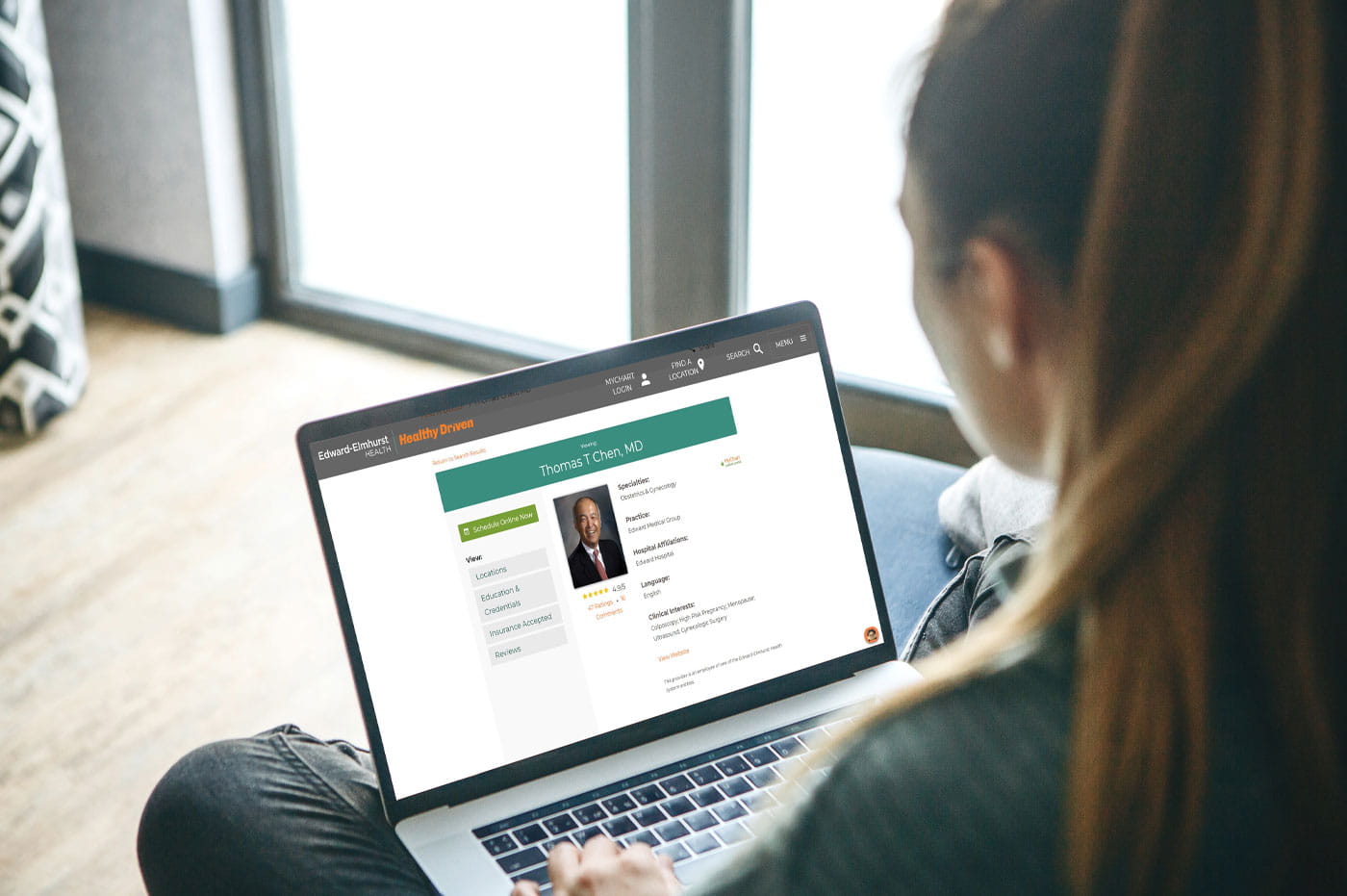 Woman looking at a doctor's information page on a laptop.