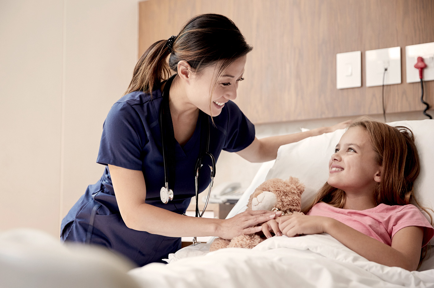 Female healthcare worker treating a little girl patient.
