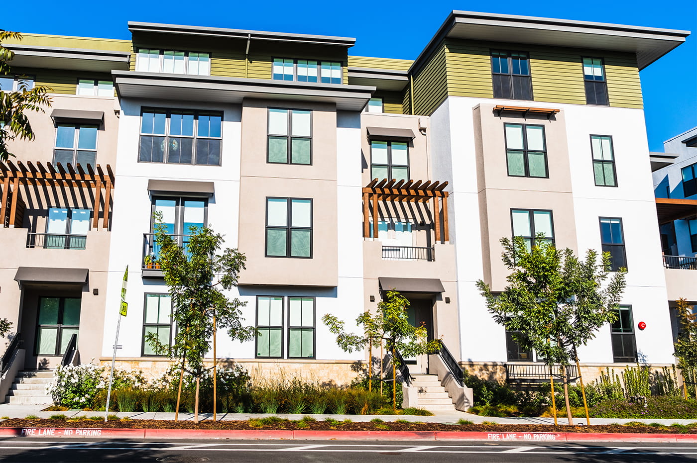 Front of a yellow, white, and beige apartment building.