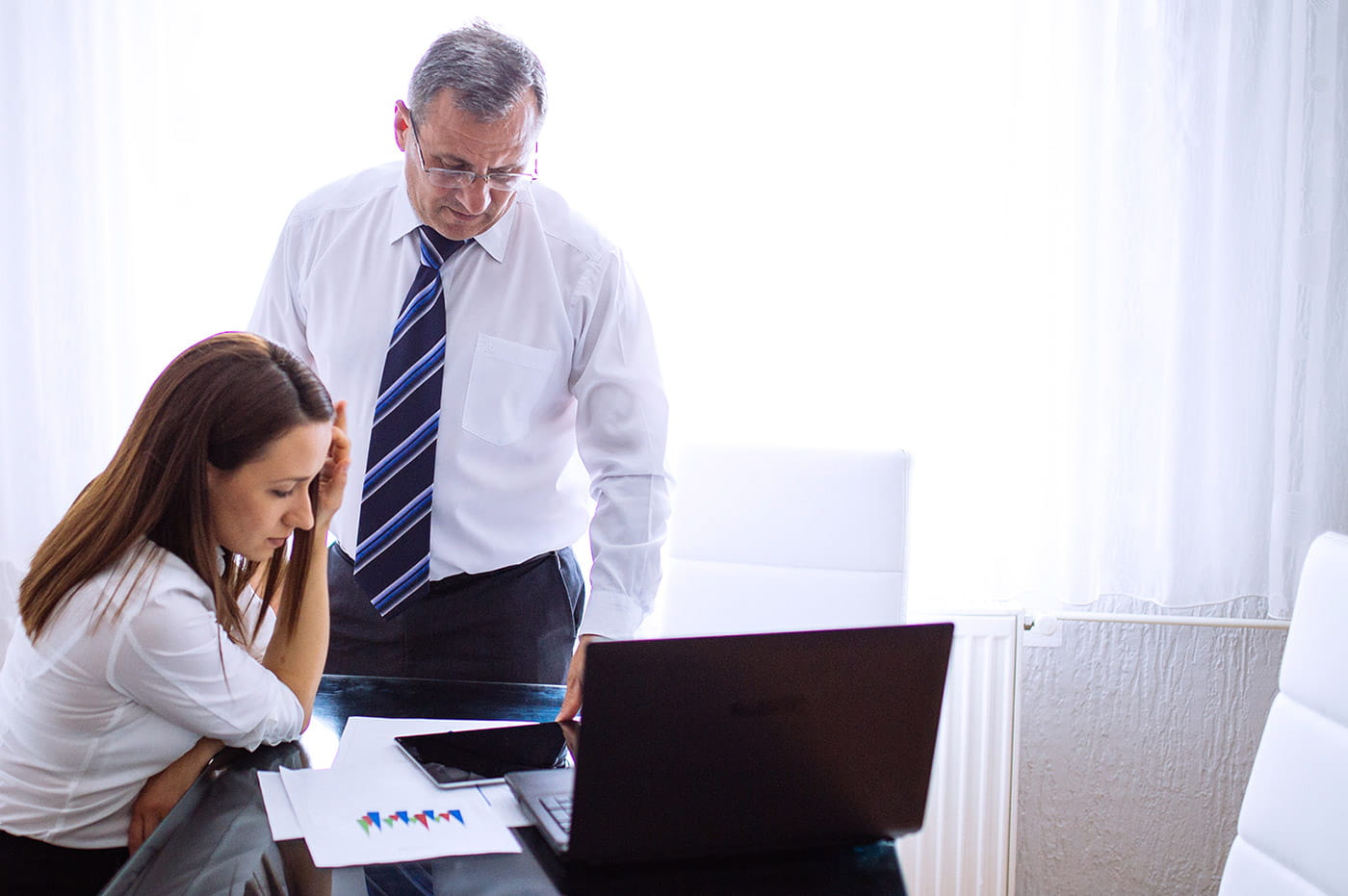 Man and woman business people looking at data charts and iPad.