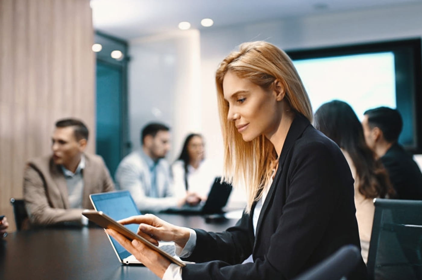 Business woman working on an iPad in a conference room.