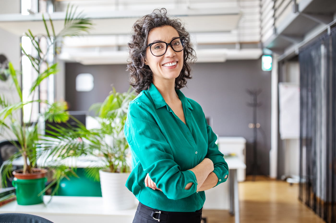 A business woman with her arms crossed smiling at the camera.
