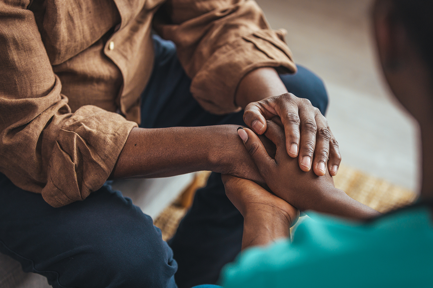 A couple tenderly holding hands.